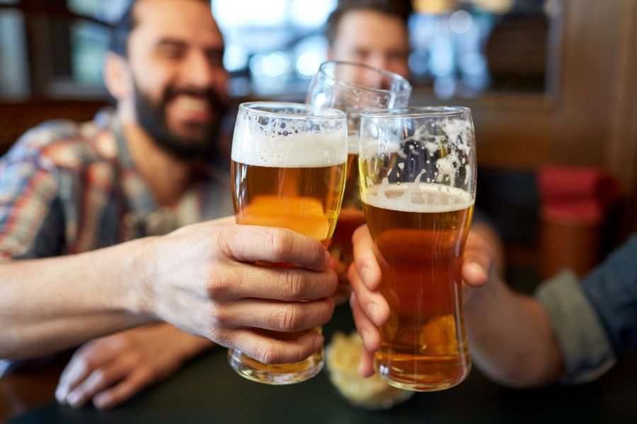 Gesellige Runde, die mit Bier anstößt